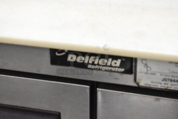 Delfield 4448N-12 stainless steel sandwich prep table, visible branding, on commercial casters, 115V, 1 phase.