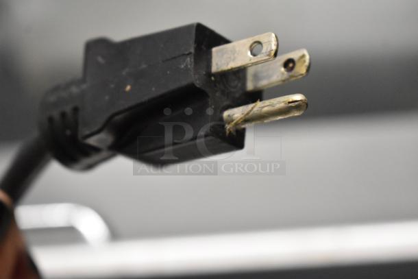 Close-up of a three-prong plug from a Delfield 4448N-12 Sandwich Salad Prep Table, 115 volts, 1 phase.