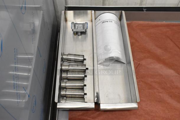 Brand new Garland stainless steel commercial countertop flat top griddle, visible components, and manual in packaging.