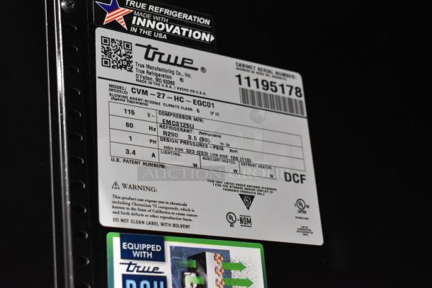 True CVM-27-HC label detailing model, voltage, compressor info, and warnings on a scratch and dent commercial cooler.