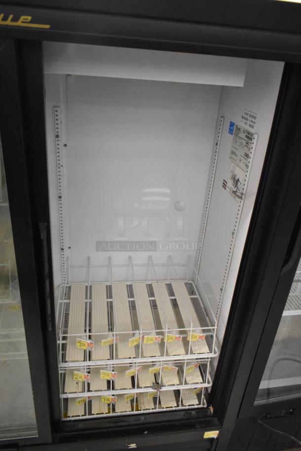 True GDM-41SL-60-LD commercial 2-door cooler with poly-coated racks, metal exterior. Visible labels and pricing tags inside.