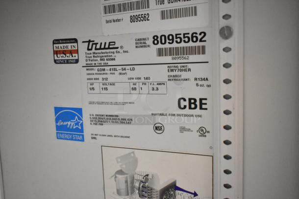 True GDM-41SL-54-LD cooler tag indicating model, voltage (115V), phase (1), refrigerant (R134A), and serial number 8095562.