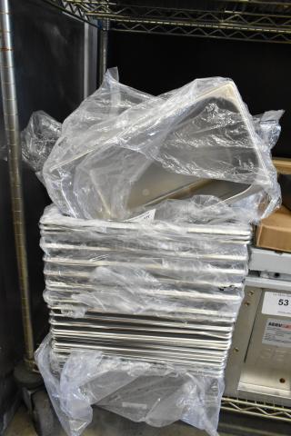 39 stainless steel drop-in bins, scratch and dent condition, sizes 4070369 1/3x6, 4070069 1/1x6, 4070063 1/1x6 perforated, stacked with packaging.