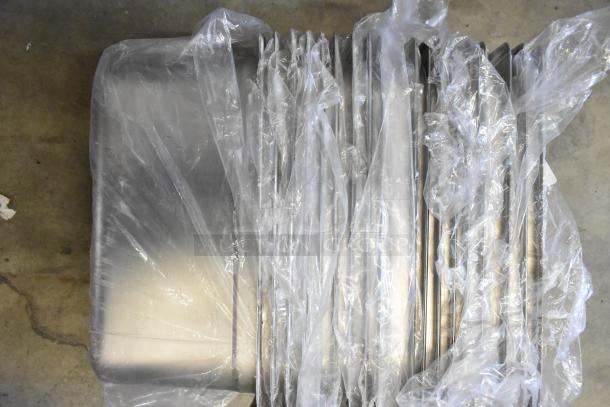 39 brand new stainless steel drop-in bins, various sizes, covered in protective plastic. Ready for auction.