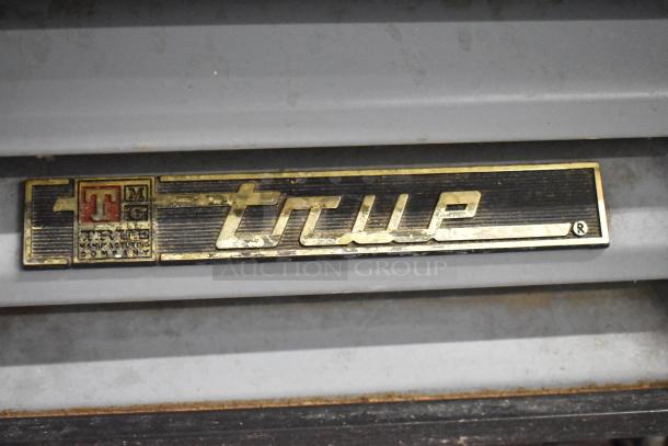 True GDM-12-LD metal commercial cooler, single door, 115 volts, 1 phase, True logo plate visible, good condition.