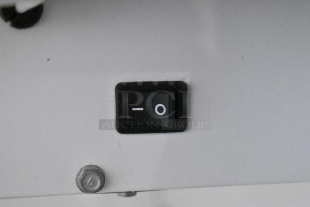 Switch detail of True GDM-12-LD cooler, showing an on/off button on a white panel.