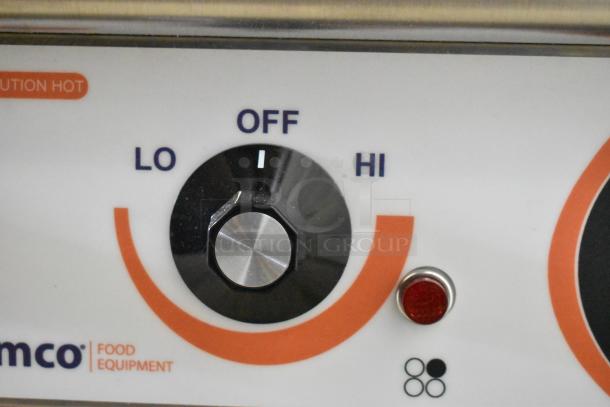 Control knob of a Nemco 6311-4-240 stainless steel commercial hot plate, showing settings from low to high. Brand and power indicator visible.