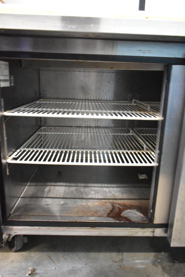 2018 Atosa MPF8202GR stainless steel pizza prep table with shelves, commercial casters, some rust. 115V, 1 phase.
