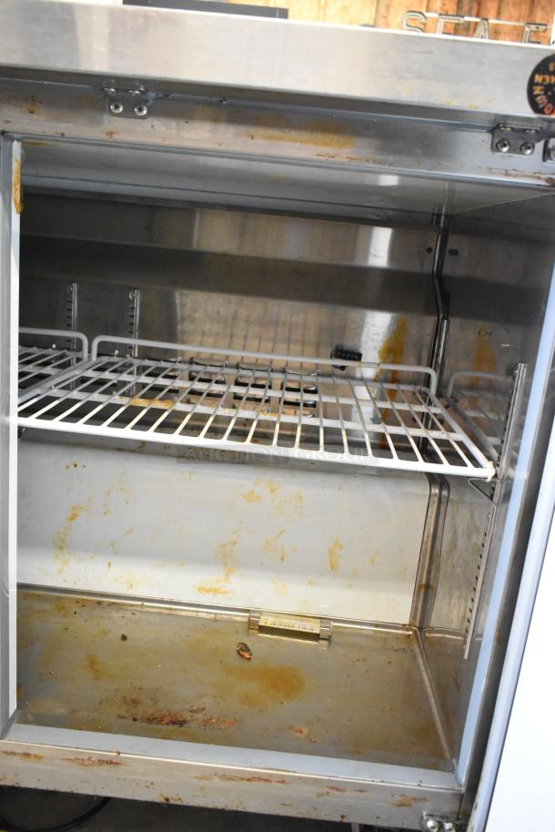 Atosa 178AU48FHC stainless steel 2-door undercounter freezer, commercial casters, visible wear inside, model label present.