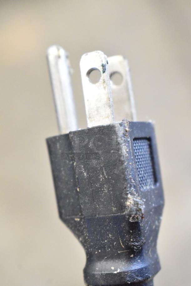 Close-up image of a standard plug from the Atosa 178AU48FHC freezer, showing three metal prongs in used condition.