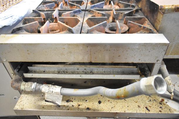 Royal RHP-24-4 stainless steel 4 burner propane range, 30,000 BTU, commercial use, visible wear, attached gas hose.