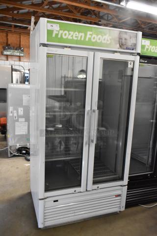 Turbo Air TGF-35SDW-N commercial freezer, two glass doors, poly coated racks, 115V, excellent condition, visible "Frozen Foods" sign.