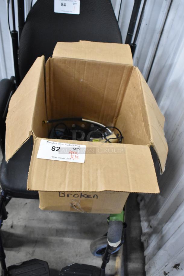 Box labeled "Broken" containing various items including digital cameras, Garmin GPS, and Hach colorimeters. Tag reads "QTY Approx. X15."