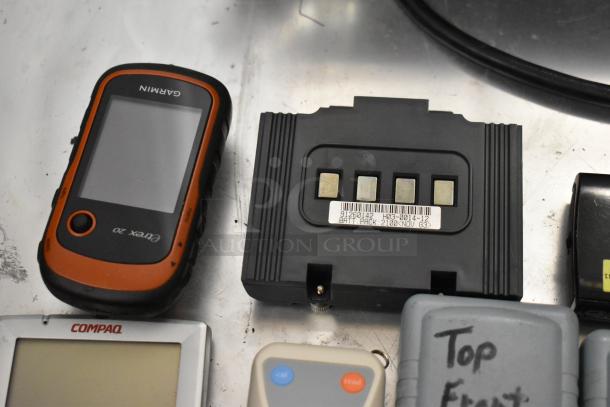 Assortment of 15 items including Garmin eTrex 20 GPS device, Compaq digital device, and other electronics.