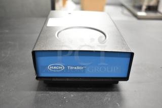 Hach TitraStir Stir Plate, 115 Volts, 1 Phase. Blue and black design, Hach logo visible. Appears in good condition.
