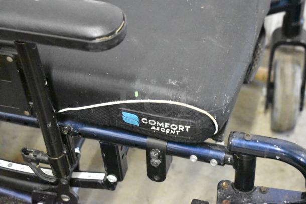 Comfort Ascent Wheelchair with padded seat, minor scuffs, sturdy frame. Logo visible on side panel.