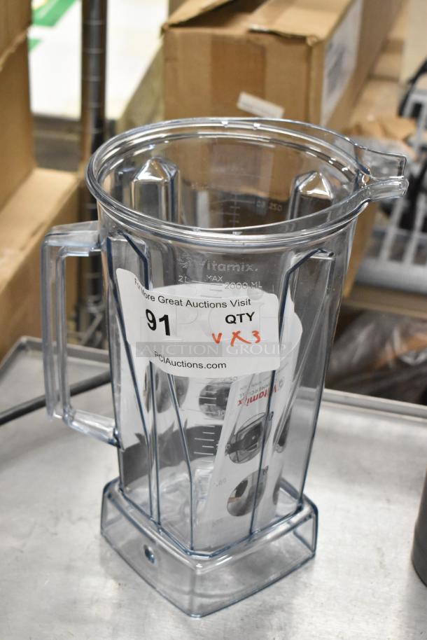 Vitamix poly blender pitcher with measurement markings, labeled for auction; includes a metal drying rack and pitcher.