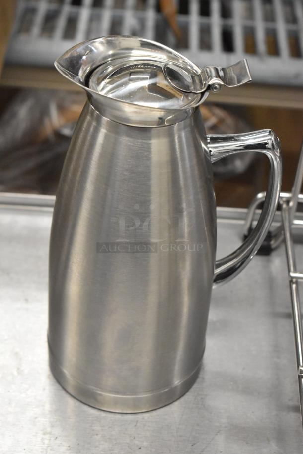 Metal pitcher with a spout and handle, in good condition. Part of a set with a metal drying rack and poly blender pitcher.