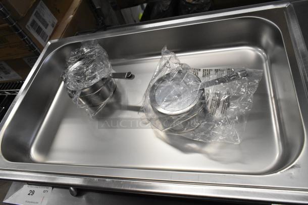 New stainless steel chafing dish with minor scratches. Includes wrapped accessories. Durable catering essential.