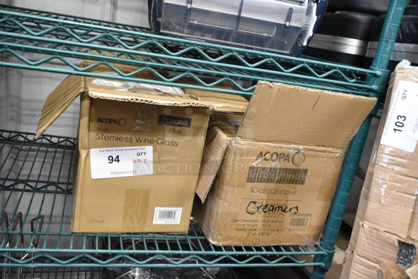 Two boxes on a shelf, one labeled "Acopa Pangea Blue 15 oz. Stemless Wine Glass" and the other "Acopa Keystone 10 oz. Stoneware Creamer". Both boxes indicate 12 per case. Item condition: new, scratch and dent.