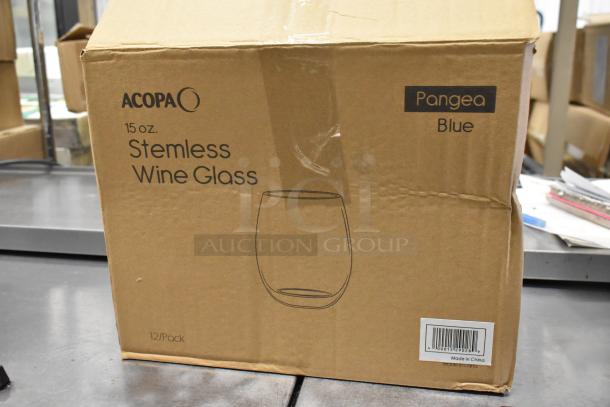 Cardboard box labeled "Acopa Pangea 15 oz. Blue Stemless Wine Glass, 12/Case, Made in China," on a metal surface. Box condition shows minor dents.
