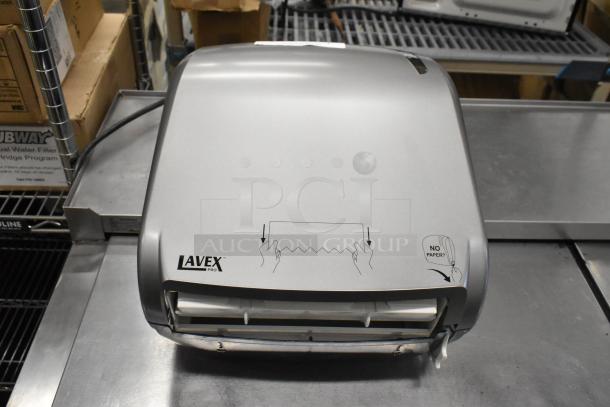 Brand new Lavex poly wall mount paper towel dispenser, silver, minor scratches, instructional icons, model branding visible.