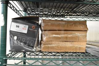 Packaged Stolzle Ultra 16 oz wine glasses and Oneida 12" porcelain plates on a shelf, labeled "98 QTY VXY," scratch and dent condition.