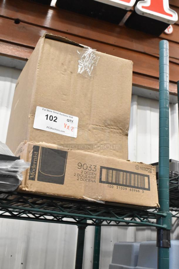 Cardboard boxes labeled "Modernist" and "Reserve" on shelf. Contains 500GBWL750C wine bottles, Reserve 7 oz. glasses. Tags show "102 QTY x2".