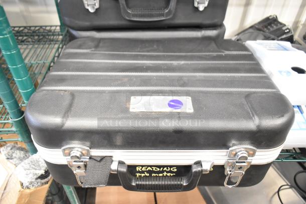 A black hard case with metal latches and a handle labeled "READING prob meter." Signs of use are visible on the surface.