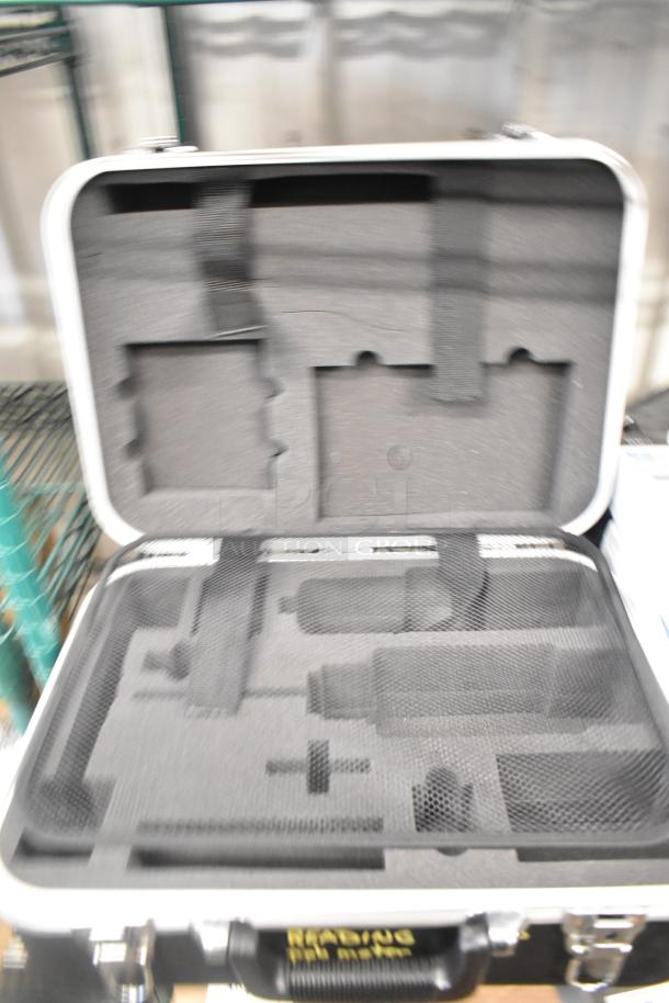 Open hard case with foam interior, outlined for equipment storage, part of 9 various items including weight plates.