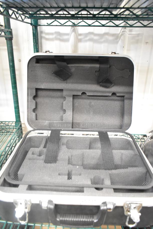 Open hard case with foam interior, designed for secure storage. One of nine assorted auction items, including weight plates.