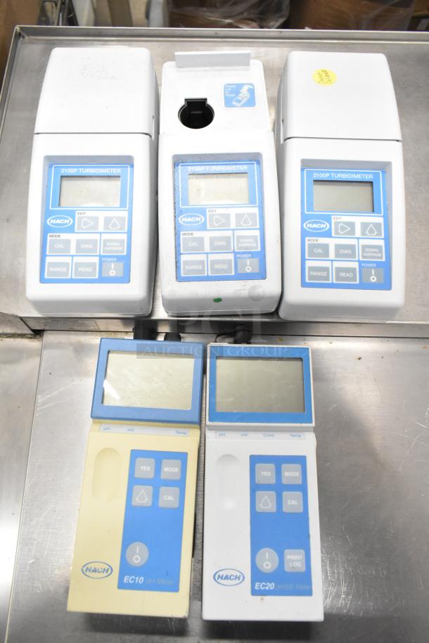Eight assorted lab items including Hach 2100P turbidimeters, EC20 meters. Visible labels, fair condition.