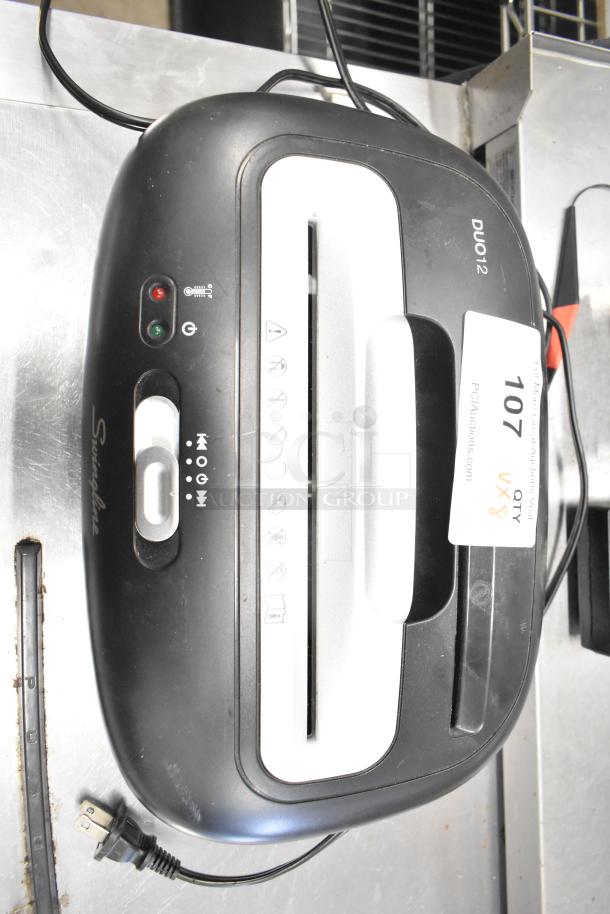 Swingline paper shredder, black and silver, featuring a DUO12 model. Includes operational buttons and shredder capacity label.