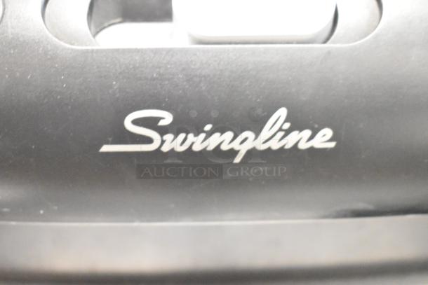 Swingline paper shredder, black, close-up of logo. Part of auction lot with multiple office and lab items.