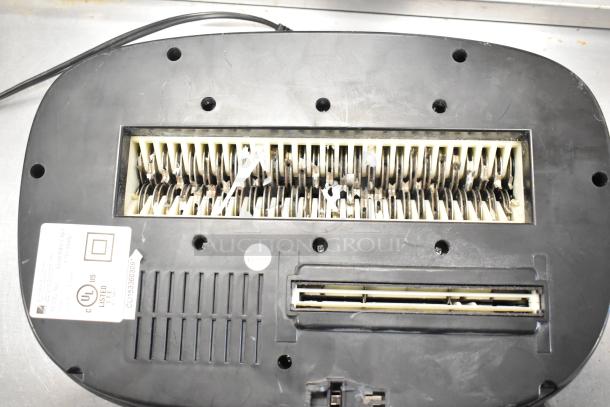 Bottom view of a Swingline paper shredder showing shredding blades and safety label. Used condition.