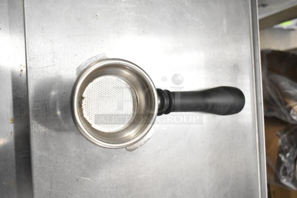 Stainless steel portafilter with black handle, used condition, part of a 3-piece set. Ideal for espresso machines.