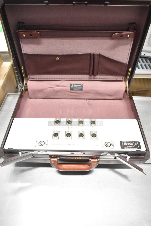 Samsonite classic burgundy briefcase with interior label, holding electronic equipment with multiple connectors.