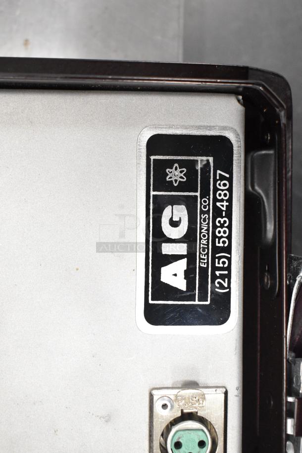 Label reading "AIG Electronics Co, (215) 583-4867" on metal device panel, part of auction lot including pipette tips and ion meter.