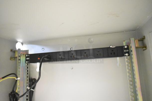 BlackShields DC0300 white metal air-conditioned cabinet with rack unit, showing power strip and cable management inside.