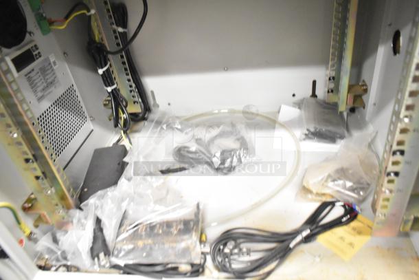 White BlackShields DC0300 metal technology cabinet with rack unit, wiring, and components inside; model label visible.