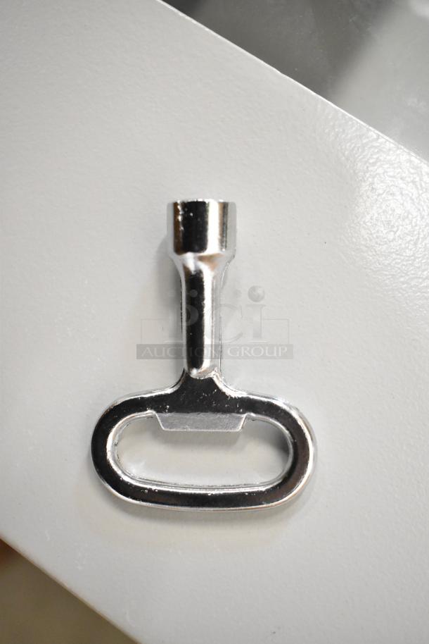 Metal key on the door of a BlackShields DC0300 white metal air-conditioned technology cabinet.