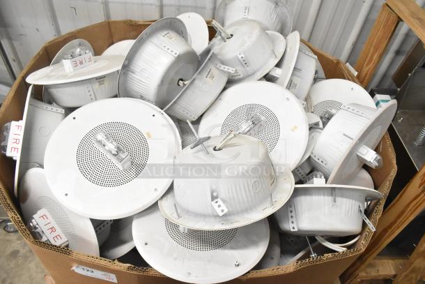64 Wheelock CBB-8 speakers with fire alarm lights in a lot. White, round design. Visible labels marked "FIRE." Used condition.