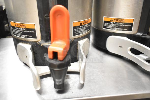 Two Bunn SH SERVER stainless steel coffee satellite servers, each with an orange spout and visible warning labels for hot liquid.