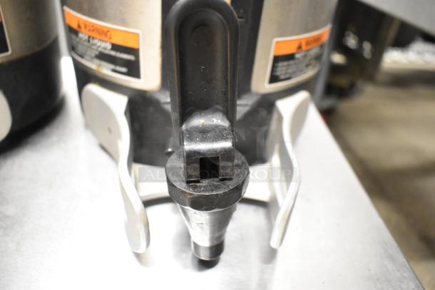 Two Bunn SH SERVER stainless steel coffee satellite servers, showing spouts and handles. Good condition with visible warning labels.