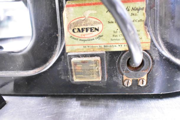 Metal commercial countertop espresso bean grinder, 115 volts, 1 phase, features label with contact info and branding.