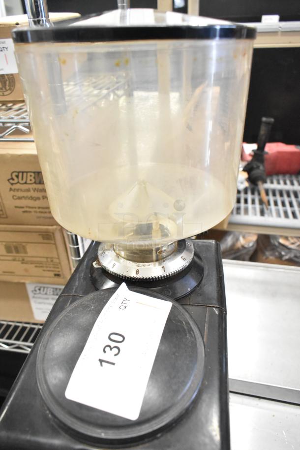 Metal commercial countertop espresso bean grinder, black, adjustable dial, minor wear. Voltage: 115V, 1 phase. Auction tag visible.