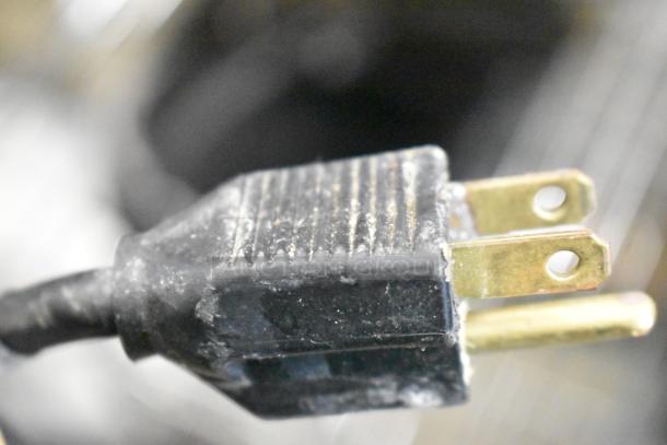 Close-up of a two-prong plug connector, possibly belonging to Duke CSW-2-T-AM food warmer, showing signs of wear.