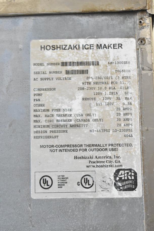Hoshizaki KM-1300SRH stainless steel commercial ice head on bin. Model details show 208-230V, 1 phase. Label features voltage and compressor specs.