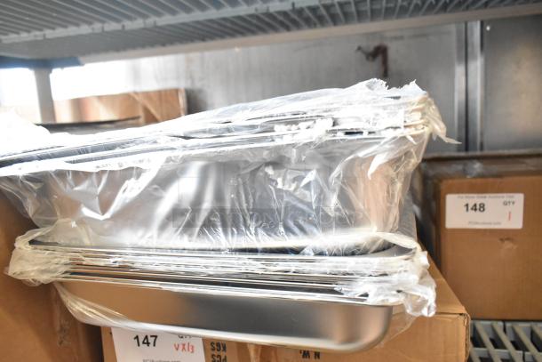 Brand new stainless steel drop-in bins wrapped in plastic, with chafing dish frames, labeled "13X your bid."