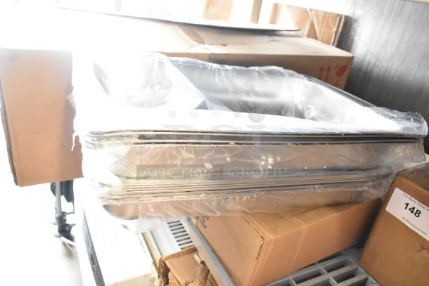 13 brand new scratch and dent stainless steel drop-in bins and folding chafing dish frames, packed in cardboard boxes.
